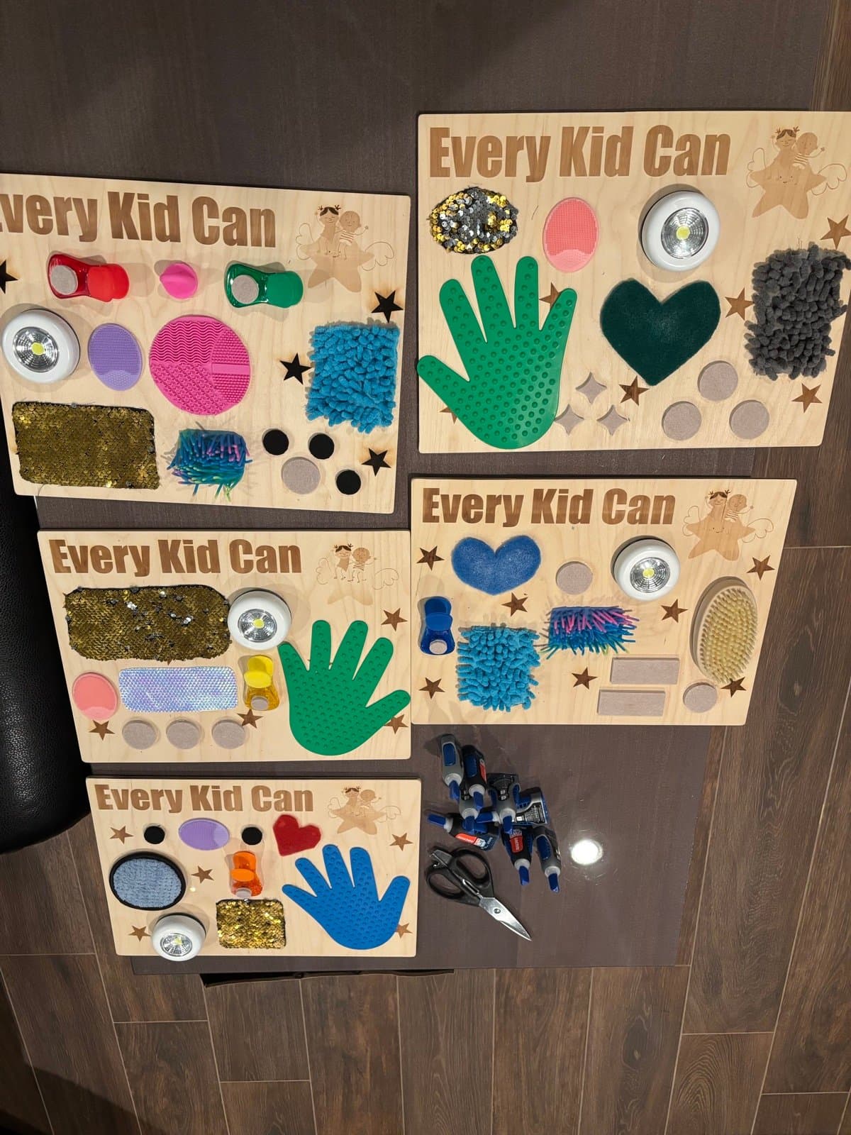 Five completed Every Kid Can sensory boards with colorful tactile elements
